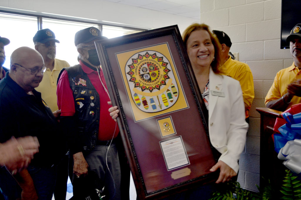 The Lumbee Warriors present Melissa Singler with a plaque. Each feather on the plaque represents the wars and conflicts that they have been involved in from WWI to the present day.